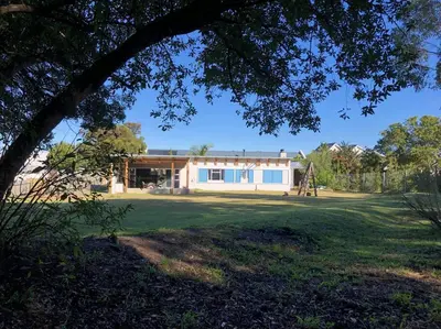 a house with a playground in front of a yard at Rustica in Onrus close to the beach in Hermanus