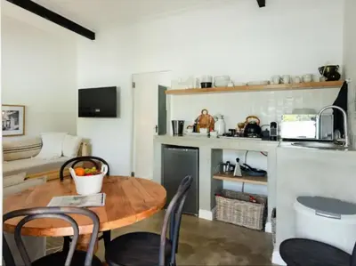 a kitchen and dining room with a table and chairs at Nooitgedacht Guest Farm Cottages in Kayamnandi
