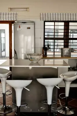 a kitchen with a counter and stools in a kitchen at Mar-a-Stella Self-Catering Family Retreat in Bettyʼs Bay