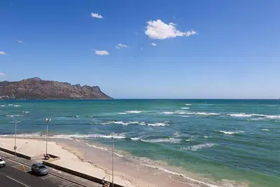 a view of the ocean and a beach with cars at 302 Ocean View in Strand