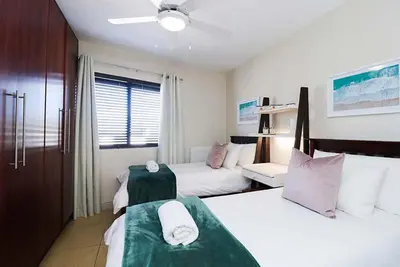 a bedroom with two beds with green and white at 302 Ocean View in Strand