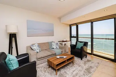 a living room with a couch and chairs and a table at 302 Ocean View in Strand
