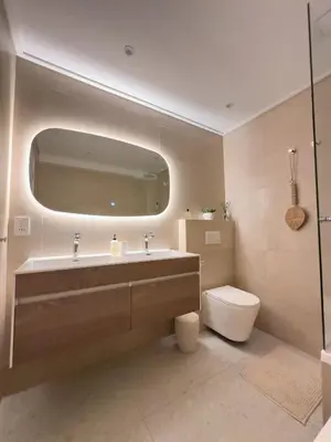 a bathroom with a sink and a toilet and a mirror at Happy Dolphin - Luxury 3BR Sea View Apartment in Cape Town