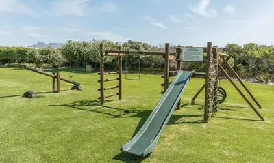 a playground with a slide in a park at Happy Dolphin - Luxury 3BR Sea View Apartment in Cape Town