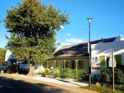 a green building with a tree in front of it at Greyton Toad Hall Historic Private House in Central Greyton in Greyton
