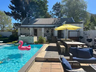 a swimming pool with a pink flamingo in a backyard at Greyton Toad Hall Historic Private House in Central Greyton in Greyton