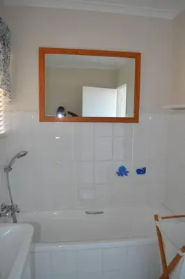 a bathroom with a mirror and a bath tub at Simplicity with an ocean view 200 in Hermanus