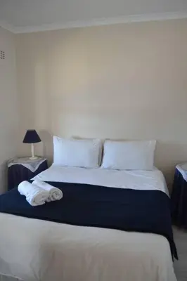a bed with two pillows and a towel on it at Simplicity with an ocean view 200 in Hermanus