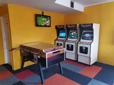 three video game machines in a room with a table at Simplicity with an ocean view 200 in Hermanus