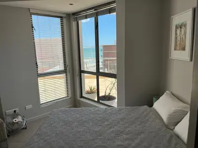 a bedroom with a bed and a view of the ocean at 502 Hibernian Towers in Cape Town