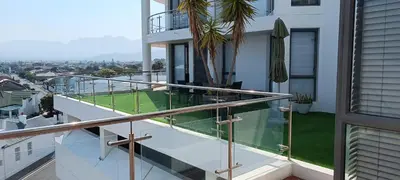 a balcony with glass railing and a view of a city at 502 Hibernian Towers in Cape Town