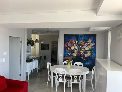 a dining room with a table and a painting on the wall at 502 Hibernian Towers in Cape Town