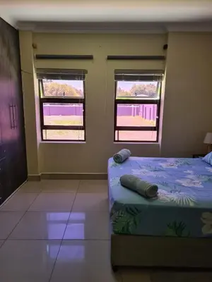 a bedroom with two windows and a bed in it at Pemba's residence in Cape Town