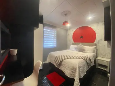 a small bedroom with a bed with a red headboard at Kwaaamiii in Cape Town