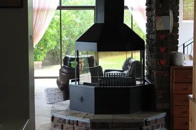 a fireplace in a living room with a chair in it at 19th Hole Golf Villa Guesthouse in Worcester