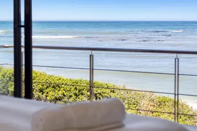 a view of the beach from a balcony at Hangklip Villa in Pringle Bay