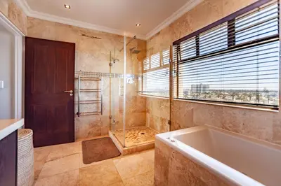 a large bathroom with a tub and a shower at Luxury 3 bedroom Duplex Penthouse with communal swimming pool in Bloubergstrand