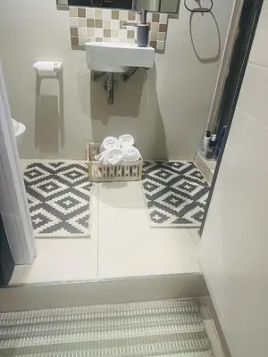 a bathroom with a sink and a basket of towels at Tranquil Pool View in Cape Town