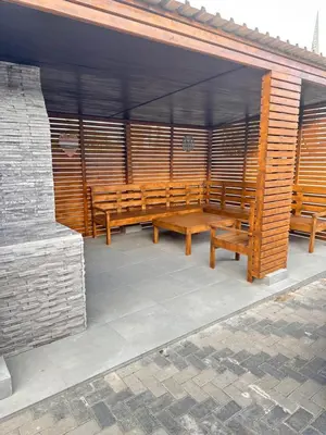 a row of wooden benches under a pavilion at Malaika Guest House in Cape Town