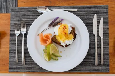 a plate of food with an egg and vegetables on a table at Banhoek Lodge in Stellenbosch