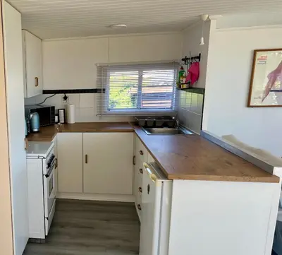 a kitchen with white cabinets and a wooden counter top at Fantastic spot In Hermanus with great lagoon views in Hermanus
