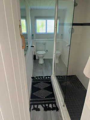 a bathroom with a toilet and a glass shower at Fantastic spot In Hermanus with great lagoon views in Hermanus