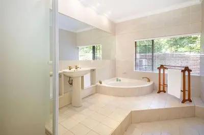 a bathroom with a tub and a sink and a bath tub at The Oasis of Stellenbosch in Stellenbosch