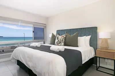 a bedroom with a large bed with a view of the ocean at Zeezicht 204 Bloubergstrand in Bloubergstrand