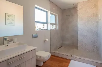 a bathroom with a shower and a toilet and a sink at Family home in Tableview, close to Dolphin Beach. in Cape Town