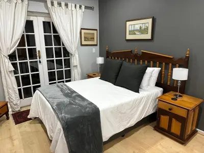a bedroom with a large bed and two windows at Bordeaux 45 in Cape Town