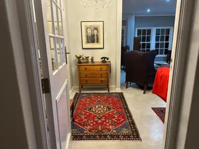 a hallway with a room with a dresser and a rug at Bordeaux 45 in Cape Town