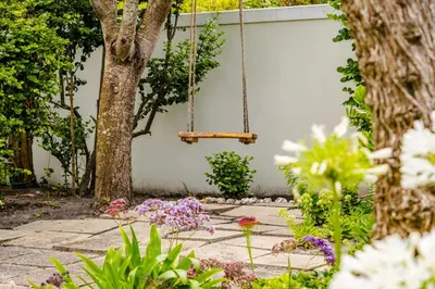 a swing in a garden with flowers at 3 on Vermont in Hermanus