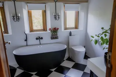 a bathroom with a black tub and a toilet at Berghuis - Mountain Hideaway in Wolseley