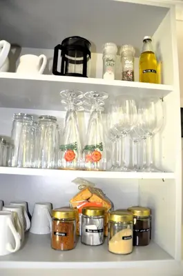 a shelf with glasses and other items in a refrigerator at The Beach Cottage Betty's Bay in Bettyʼs Bay