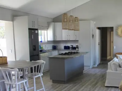 a kitchen with a table and a counter top at Nest Egg Holiday Home Voëlklip in Hermanus