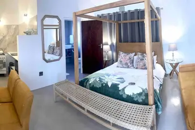 a bedroom with a canopy bed and a mirror at Franschhoek - A Sensory Escape in Franschhoek