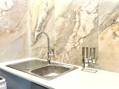 a sink in a kitchen with a marble wall at Franschhoek - A Sensory Escape in Franschhoek