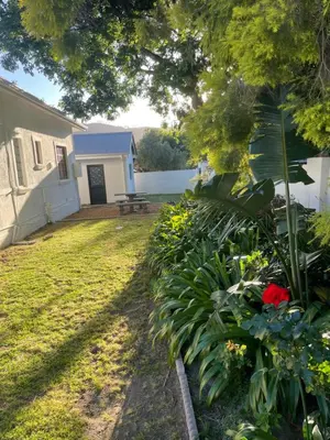 a yard with a house and some flowers at Franschhoek - A Sensory Escape in Franschhoek