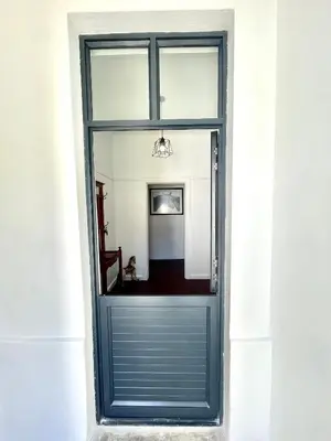 a blue garage door in a white wall at Franschhoek- African dream in Franschhoek