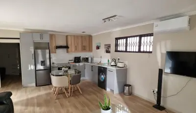 a kitchen with a sink and a table in a room at Sunset Getaways in Cape Town