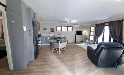 a living room with a kitchen and a dining room at Sunset Getaways in Cape Town