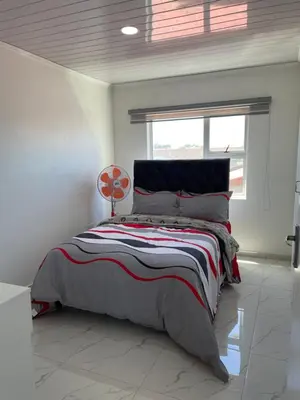 a bedroom with a bed in a room with a window at The MK House in Cape Town