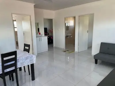 a living room with a table and a chair at The MK House in Cape Town