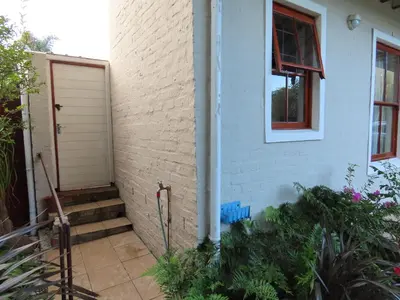 a white house with a door and a window at Belle View Guest Suite in Hermanus