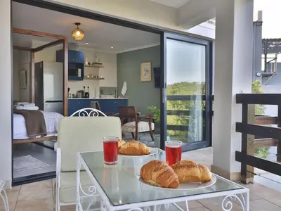 two plates of croissants on a glass table in a room at Salt Shore Studios in Hermanus