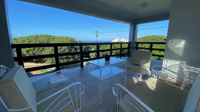 a balcony with a glass table and chairs on it at Salt Shore Studios in Hermanus