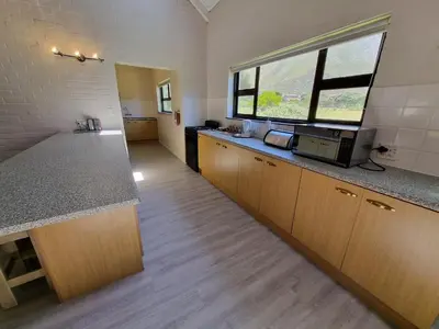 a kitchen with a counter and a window at Milkwood Cottage in Bettyʼs Bay
