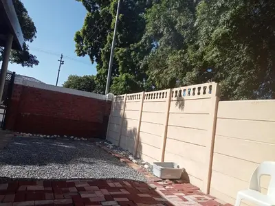 a fence in front of a brick wall at ATHOME BELLVILLE Chrismar in Cape Town