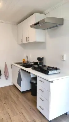 a kitchen with white cabinets and a counter top at Blissful Country Garden King Bed Cottage in Grabouw