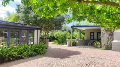 a house with a patio and a garden at Blissful Country Garden King Bed Cottage in Grabouw